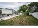 Spacious backyard featuring a screened-in pool, landscaping, and privacy fence at 11209 Kangley Ln, Spring Hill, FL 34608