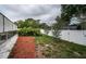 Backyard showcasing landscaping, privacy fence, and screened-in pool at 11209 Kangley Ln, Spring Hill, FL 34608