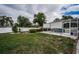 Manicured backyard showcasing a screened-in pool and privacy fence at 11209 Kangley Ln, Spring Hill, FL 34608