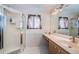 Bathroom featuring a glass-enclosed shower, vanity with sink, and decorative mirror with lighting at 11209 Kangley Ln, Spring Hill, FL 34608
