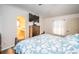 Spacious bedroom with a large bed, TV, and an ensuite bathroom visible through an open doorway at 11209 Kangley Ln, Spring Hill, FL 34608