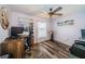 Bedroom with lavender walls, wood-look flooring, ceiling fan, and a desk setup with computer at 11209 Kangley Ln, Spring Hill, FL 34608