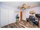 Bedroom with ceiling fan, closet, and desk area, featuring wood-look flooring and light purple walls at 11209 Kangley Ln, Spring Hill, FL 34608