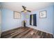 Bedroom with blue walls, wood-look flooring, ceiling fan, and decor at 11209 Kangley Ln, Spring Hill, FL 34608