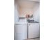 Bright laundry room with washer, dryer, and shelving for supplies, providing a functional space at 11209 Kangley Ln, Spring Hill, FL 34608