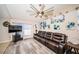 Living room with luxury vinyl flooring, comfortable leather sofa, and unique ceiling fan at 11209 Kangley Ln, Spring Hill, FL 34608