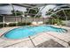 The inviting pool features clear blue water, a waterfall, and a spacious screened-in enclosure at 11209 Kangley Ln, Spring Hill, FL 34608