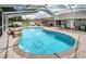 View of pool and patio featuring mature landscaping for privacy in a screened-in lanai at 11209 Kangley Ln, Spring Hill, FL 34608