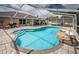 This pool features a rock waterfall and ample seating, perfect for relaxation and entertaining at 11209 Kangley Ln, Spring Hill, FL 34608