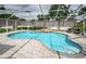 Beautiful in-ground pool features a waterfall feature, surrounded by pavers and screened enclosure at 11209 Kangley Ln, Spring Hill, FL 34608
