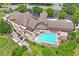 Aerial view of the community clubhouse and pool, surrounded by lush landscaping and golf carts at 11250 Hollander Ave, Hudson, FL 34667