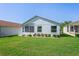 Backyard featuring manicured lawn and landscaping with back of house and screened-in lanai at 11250 Hollander Ave, Hudson, FL 34667