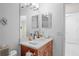 Bathroom featuring marble countertop, wooden vanity, and decorative mirrors above the sink at 11250 Hollander Ave, Hudson, FL 34667