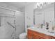 Bathroom featuring walk-in shower with white marble tile and vanity with wood cabinets at 11250 Hollander Ave, Hudson, FL 34667