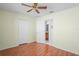 Bedroom view with open door to bathroom, ceiling fan, and wood laminate flooring at 11250 Hollander Ave, Hudson, FL 34667
