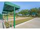 Community bocce ball court with green turf, shelters, and benches for players at 11250 Hollander Ave, Hudson, FL 34667