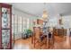 Open dining room with wood floors, stylish chandelier, and views to the kitchen and other rooms at 11250 Hollander Ave, Hudson, FL 34667