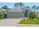 Charming single-Gathering home featuring a well-maintained lawn, a screened garage, and lovely landscaping at 11250 Hollander Ave, Hudson, FL 34667