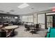 Game room area with multiple tables, seating, a pool table, and a television for community entertainment at 11250 Hollander Ave, Hudson, FL 34667