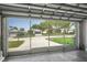 View from inside garage to neighborhood homes with manicured lawns and palm trees at 11250 Hollander Ave, Hudson, FL 34667