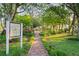 Picturesque garden path leads to a charming gazebo, surrounded by lush greenery and vibrant landscaping at 11250 Hollander Ave, Hudson, FL 34667