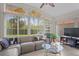 Bright living room with tiled floors, large windows, and a comfortable sectional sofa at 11250 Hollander Ave, Hudson, FL 34667