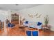 Well-lit living room showcasing wood flooring, a decorative china cabinet, and cozy furniture at 11250 Hollander Ave, Hudson, FL 34667