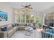 Living room featuring tile flooring, neutral sectional, and large windows for ample light at 11250 Hollander Ave, Hudson, FL 34667