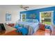 Bright main bedroom featuring a large window, and a blue accent wall with stylish decorations at 11250 Hollander Ave, Hudson, FL 34667