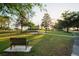 Veterans Memorial Park features lush green space, benches, and flag display, under a canopy of trees at 11250 Hollander Ave, Hudson, FL 34667