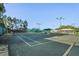 Outdoor tennis courts with nets, lighting, and shaded seating area at 11250 Hollander Ave, Hudson, FL 34667