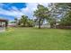 Expansive grassy backyard featuring mature trees and a fenced perimeter, creating a private outdoor oasis at 11396 Terrell Rd, Spring Hill, FL 34608