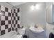 Stylish bathroom with a black and white tiled shower and a modern vanity at 11396 Terrell Rd, Spring Hill, FL 34608