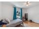 Bright bedroom with hardwood floors, single bed, and blue curtains on the window at 11396 Terrell Rd, Spring Hill, FL 34608