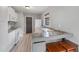 Well-lit kitchen with white cabinetry, countertops, stainless steel appliances, and hardwood floors at 11396 Terrell Rd, Spring Hill, FL 34608