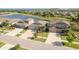 Scenic aerial view of a single Gathering home community and a small lake surrounded by lush greenery in the background at 11407 Acacia Grove Ln, Riverview, FL 33579