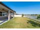 Well maintained back yard with white fence and water view, accessible from back porch at 11407 Acacia Grove Ln, Riverview, FL 33579