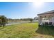 Spacious backyard with lush lawn, white fence, and serene water view at 11407 Acacia Grove Ln, Riverview, FL 33579