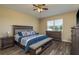 Comfortable bedroom with ceiling fan, wood floors, and a bench at the foot of the bed at 11407 Acacia Grove Ln, Riverview, FL 33579