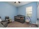 Comfortable bedroom featuring blue walls, a crib and swing for relaxation and convenience at 11407 Acacia Grove Ln, Riverview, FL 33579
