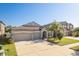 Charming one-story home featuring a well-manicured lawn, three-car garage, and attractive landscaping at 11407 Acacia Grove Ln, Riverview, FL 33579