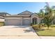 Beautiful single-story home with a three-car garage and well-maintained landscaping and green lawn at 11407 Acacia Grove Ln, Riverview, FL 33579