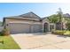 Charming single-story home with a three-car garage and well-manicured lawn, showcasing its curb appeal at 11407 Acacia Grove Ln, Riverview, FL 33579