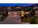 Charming single-story home with a well-manicured lawn, three-car garage, and inviting entryway at twilight at 11407 Acacia Grove Ln, Riverview, FL 33579