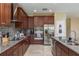 Modern kitchen with stainless steel appliances, granite countertops, and stylish dark wood cabinets at 11407 Acacia Grove Ln, Riverview, FL 33579