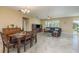Open-concept living room and dining area featuring tile flooring, a chandelier, and abundant natural light at 11407 Acacia Grove Ln, Riverview, FL 33579