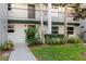 Exterior view of condo with well maintained lawn and mature landscaping at 14419 Americana Cir # 103, Tampa, FL 33613
