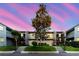Charming condo exterior with a well-maintained lawn and mature trees at sunset at 14419 Americana Cir # 103, Tampa, FL 33613