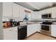 White kitchen with stainless steel appliances and granite countertops at 14419 Americana Cir # 103, Tampa, FL 33613