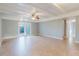 Spacious living room featuring neutral tile flooring, ceiling fan and double doors to outdoor area at 14419 Americana Cir # 103, Tampa, FL 33613